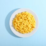 Bowl of macaroni and cheese on a blue background