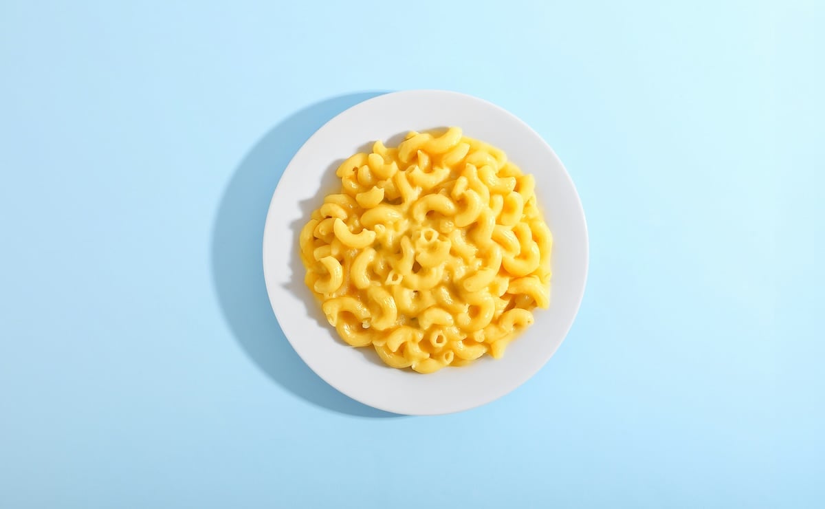 Bowl of macaroni and cheese on a blue background